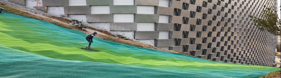 Along the industrial building's front, the ski slope goes all the way down to ground level.