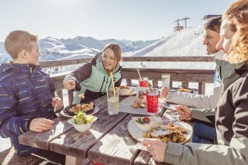 Auf den Sonnenterrassen der Hütten und Bergrestaurants genießt du leckere Tiroler Schmankerl bei bester Aussicht.
