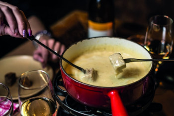 In Scuol kannst du in einer Gondel ein leckeres Käse-Fondue genießen.