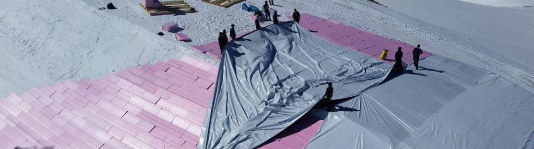 In Kitzbühel wird das Schneedepot zunächst mit Hartschaumplatten und Folie abgedeckt.