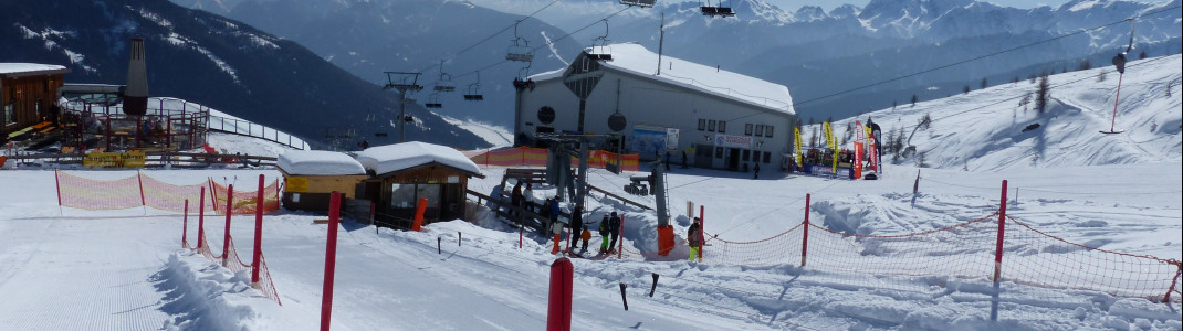 Alles auf einen Blick - Das Übungsgelände (vorn), der Skiverleih an der Bergstation und der Skischulen-Sammelpunkt