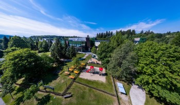 Außenansicht im Sommer mit Biergarten und Spielplatz