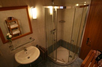 Badzimmer mit Dusche, Waschbecken und Toilette