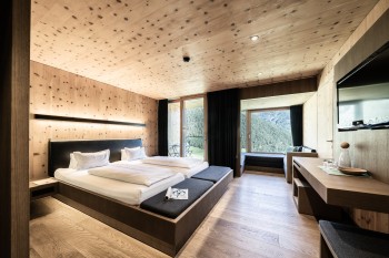 Viel Holz und Glas prägen die Zimmer, Suiten und Chalets.