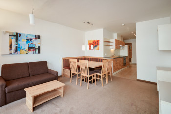 Der Wohnbereich besteht aus einer Sitzecke, einem Sofa, einem TV und dem Balkon.