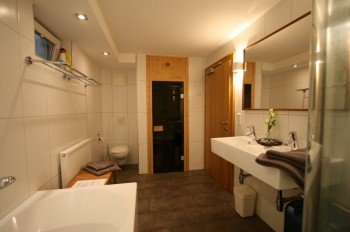 Badezimmer mit Whirlpool-Dusche und Sauna