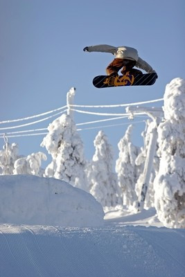Im Snowboard-Park springen Freestyler über Hindernisse inmitten der finnischen Wildniss.