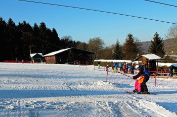 Der Burbachlift in der Wintersaison 2016/17 mit der Skihütte des SC Burbach im Hintergrund.