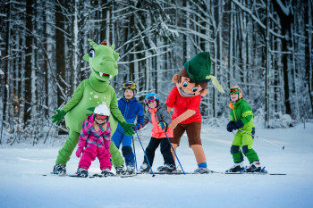 Die Kinder lernen auf den kleinen Hang das Skifahren spielerisch