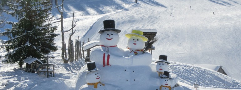 An der Rotwand begrüßt eine mehrere Meter hohe Schneemannfamilie die Skifahrer